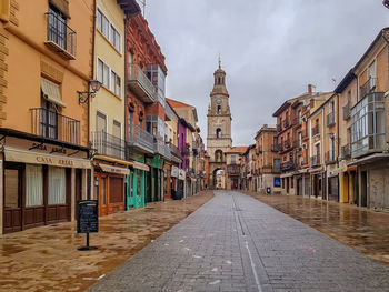 Street amidst buildings against sky in city