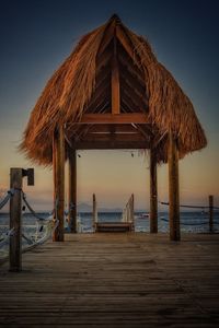 Pier on beach against clear sky