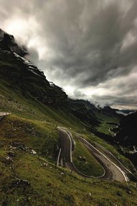 Scenic view of mountain road against cloudy sky