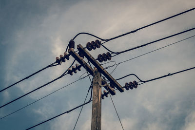 Low angle view of electricity pylon against sky