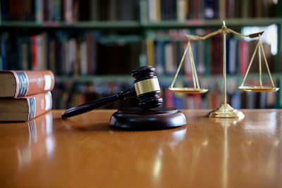 Close-up of gavel and weight scale on table in courtroom