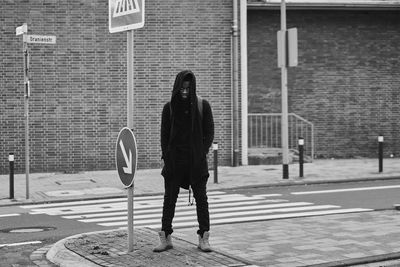 Full length of woman walking on footpath against building