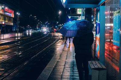 Man standing on tram station at night