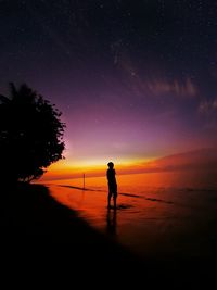 Silhouette of person standing on field against sky at night