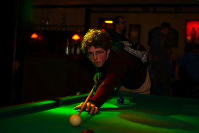 Man playing pool in darkroom