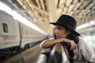 Portrait of young woman looking away at railroad station