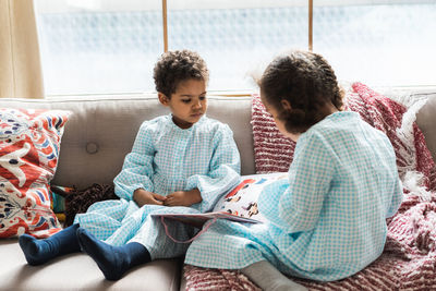 Rear view of boys sitting on sofa