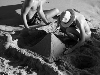 Man and woman preparing sandcastle at beach