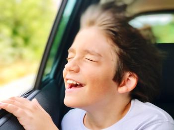 Close-up of smiling boy in car