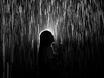 Silhouette woman standing by light painting at night