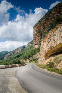 Road by mountain against sky