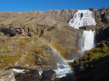 Low angle view of waterfall against clear sky