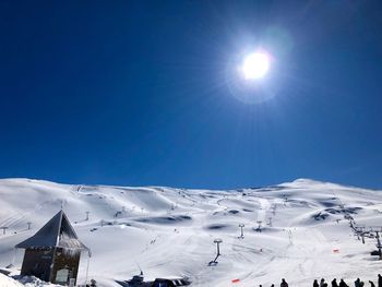 Low angle view of snowcapped mountains against clear blue sky