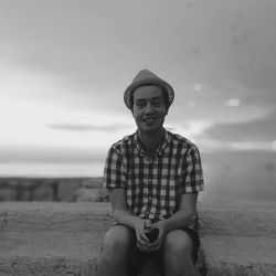 Portrait of smiling man sitting on beach