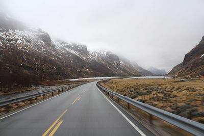 Road passing through mountains against sky