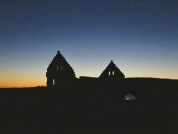 Silhouette built structure against clear blue sky