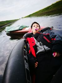 Beautiful young woman in lake against sky