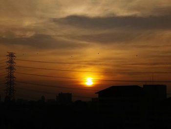 Silhouette city against sky during sunset