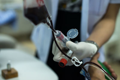 Midsection of nurse holding blood bag in hospital