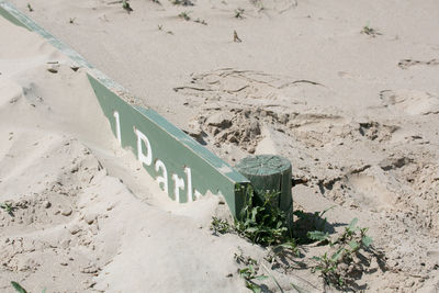 High angle view of signboard on sandy beach