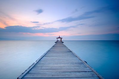 Pier over sea against sky during sunset