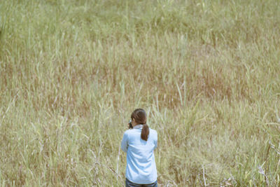Rear view of woman standing on field