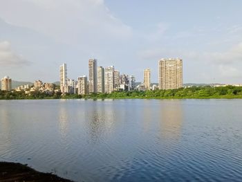 Sea by buildings against sky in city