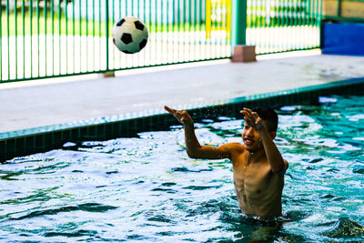 Man playing with ball in swimming pool