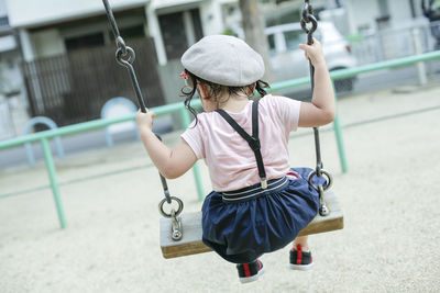 Full length of cute girl holding hat