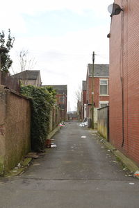 Road amidst buildings in city against sky