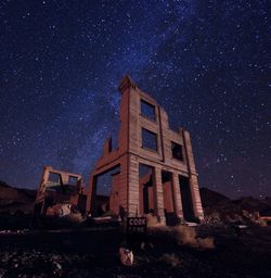 Low angle view of abandoned building against sky at night