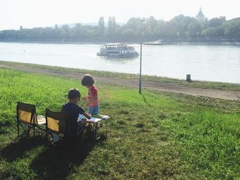 Rear view of man sitting on bench in park