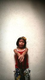 Girl standing against wall at home