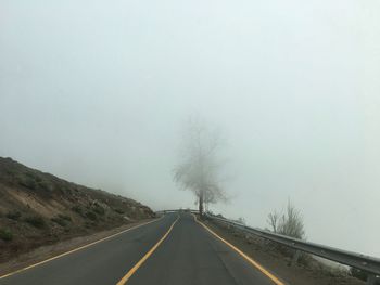 Empty road along countryside landscape