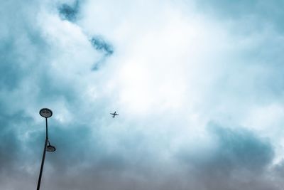 Low angle view of street light against cloudy sky