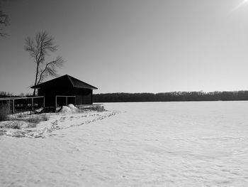 House on field against clear sky during winter