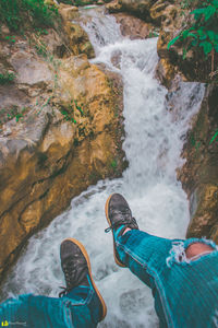 Low section of man standing on rock