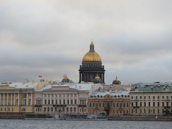 Buildings in city against cloudy sky