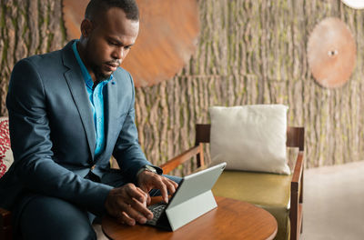 Man looking at camera while sitting in laptop