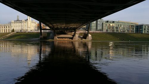 Bridge over river in city against sky