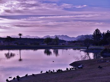 Scenic view of lake against sky at sunset