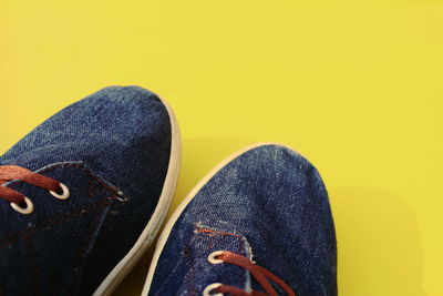 Close-up of shoes against yellow background