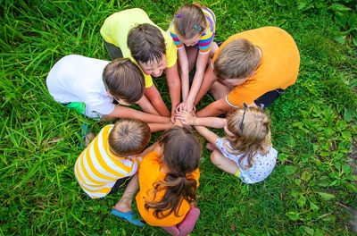 High angle view of boy playing with toys on grassy field