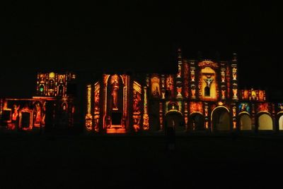 Illuminated buildings against sky at night