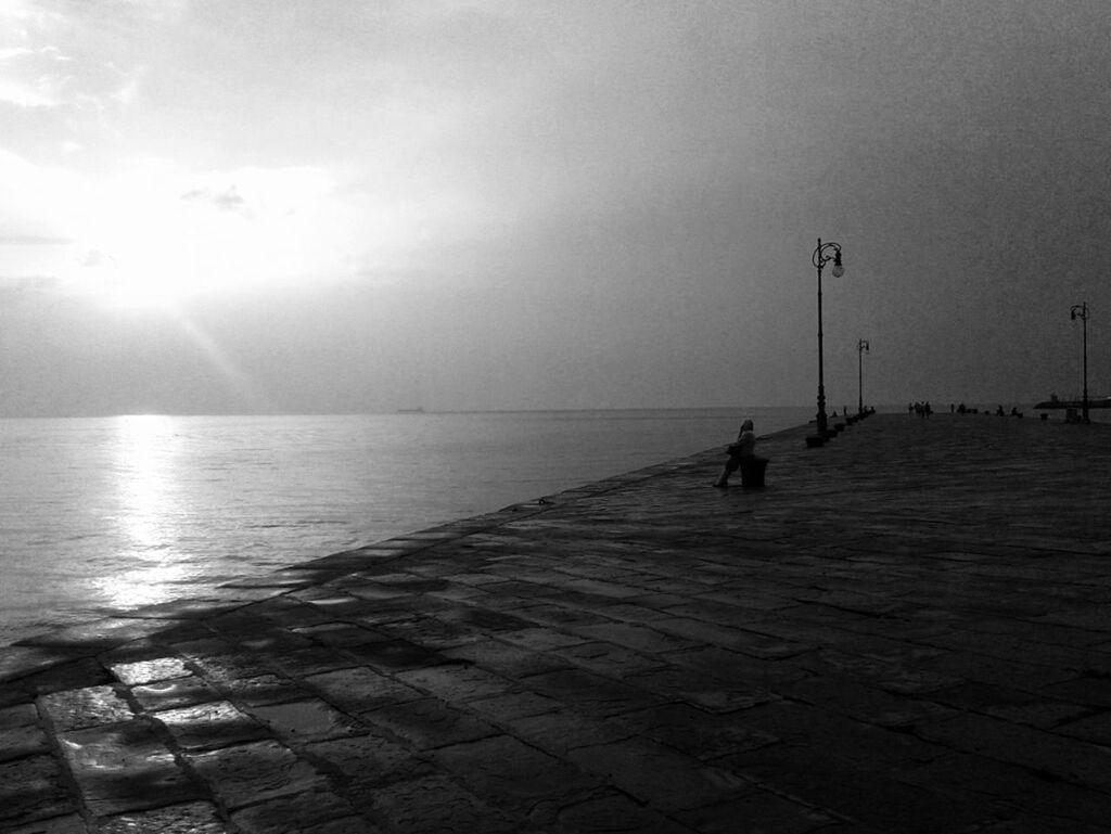 water, sea, horizon over water, sun, sky, tranquility, tranquil scene, scenics, beauty in nature, sunlight, reflection, sunset, nature, sunbeam, silhouette, idyllic, incidental people, beach, pier