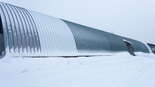 Snow covered field against clear sky