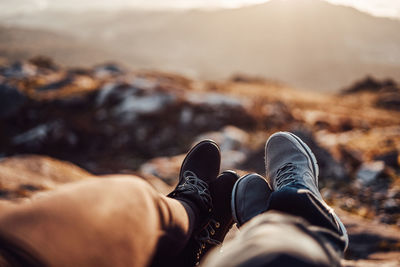 Low section of couple relaxing on mountain