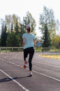 Full length of woman exercising on road