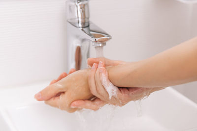 Washing hands under the flowing water tap. hygiene concept hand detail. washing hands rubbing