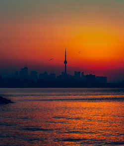 Silhouette of buildings in city during sunset